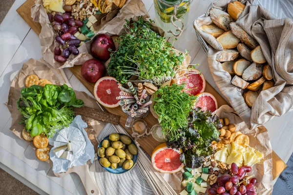 Üst kattaki konforlu oda servis masasının etrafı rahat yastıklarla çevrili ve parti kutlaması için hazır. Sağlıklı, taze, lezzetli yemek ve içecek rahat oturma odası hygge boho scandi dekoru.