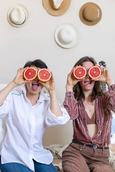 Fröhliche Freundinnen Die Mit Hälften Roter Grapefruits Auf Den Augen — Stockfoto