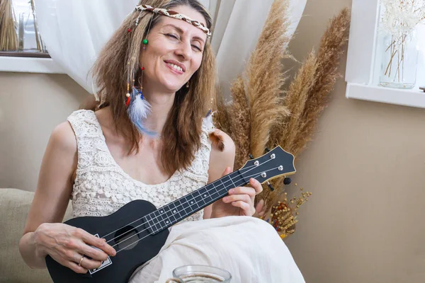 Glimlachende hippie vrouw in etnische boho scandi outfit spelen gitaar ontspannen hebben positieve emotie — Stockfoto