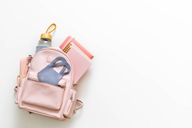 Zarif pembe öğrenci çantasının içi malzemelerle dolu. Okul konseptine dönelim.