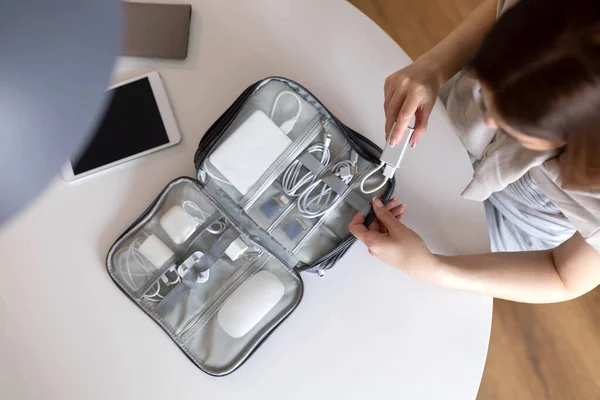 Top view vrouw zet draden tablet moderne elektronische apparaat apparatuur in comfortabele opbergtas — Stockfoto