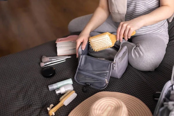 Mujer sonriente escritura lista de cosméticos necesarios preparándose viaje organización de almacenamiento de vacaciones — Foto de Stock