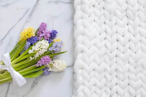 Buquê de flores coloridas de primavera de jacintos. fundo de mármore branco e macio xadrez de malha — Fotografia de Stock