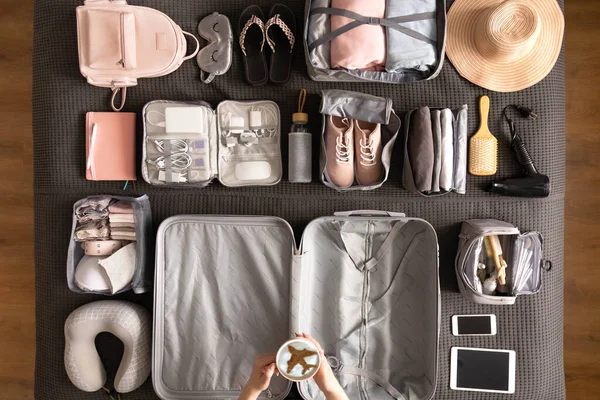 Top vista mulheres mãos se preparando para viajar férias embalagem mala uso método konmari — Fotografia de Stock