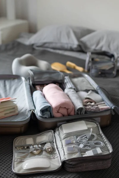 Техніка валізи дроти обладнання на ліжку. Пакет або зберігання з речами, одягом та аксесуарами — стокове фото