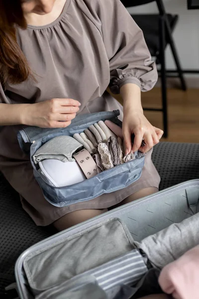 Oidentifierad kvinna sätter underkläder i resa lagringsbehållare användning konmari metod förpackning resväska — Stockfoto