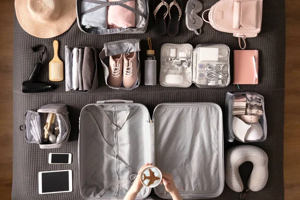 Frauenhände bereiten sich auf die Reise vor und packen Koffer mit Konmari-Methode — Stockfoto