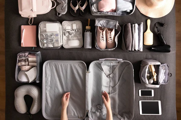 Top view vrouw handen klaar om te reizen vakantie verpakking koffer gebruik konmari methode — Stockfoto