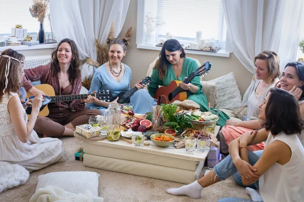 Grupo de amigos do sexo feminino tocando guitarra cantando música se divertindo em festa de galinha no estilo hippie boêmio — Fotografia de Stock