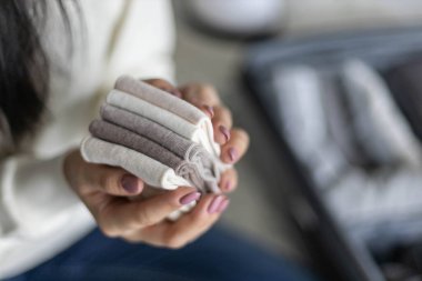 Kimliği belirsiz kadın iç çamaşırlarını konteynıra koyuyor. Konmari metodunu kullanarak bavul hazırlıyor.