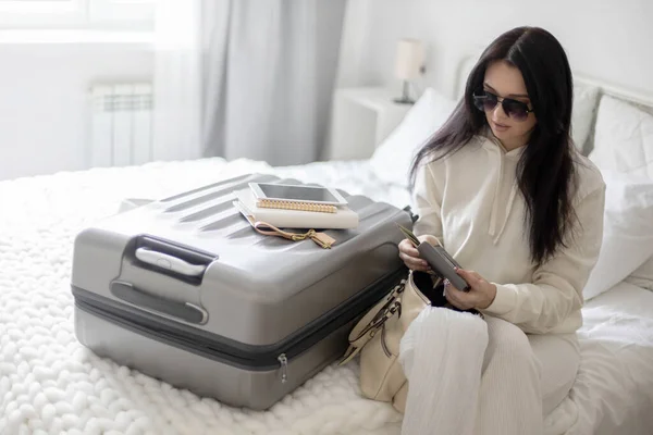 Trendy woman counting checking money cash dollar in wallet before leaving bedroom ready to travel