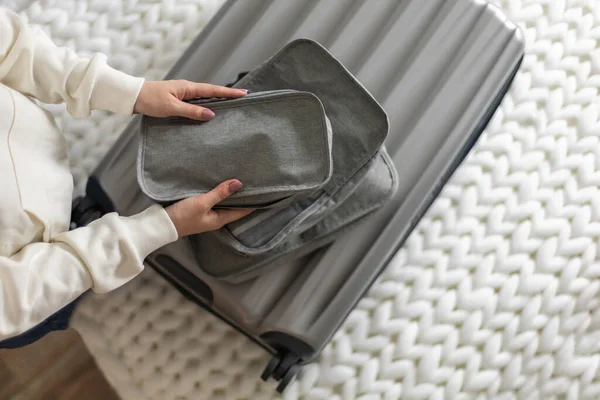 female packing things in briefcase use konmari method getting ready to travel or business trip