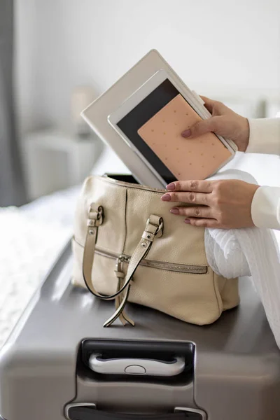 Detailní ženské ruce vkládání dokumentů tablet PC notepad deník do kabelky připraven k cestování dovolenou — Stock fotografie