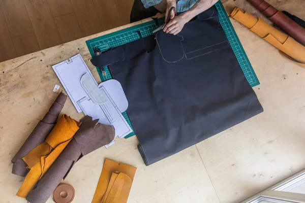 Zanaatkar, deri atölyesinde deri işçiliği yaratan bir poşet için çizim şeması çiziyor. — Stok fotoğraf