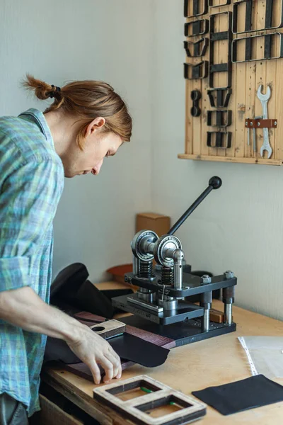 Samec koželužna pracující se strojem ruční tiskárny řezací vzor na materiál kožené dílny — Stock fotografie