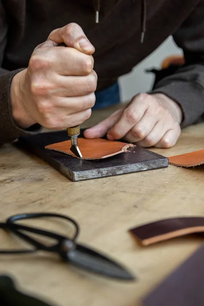 Craftsman machines edge of natural stuff workpiece use professional curly knife. Leather workshop — Stock Photo, Image