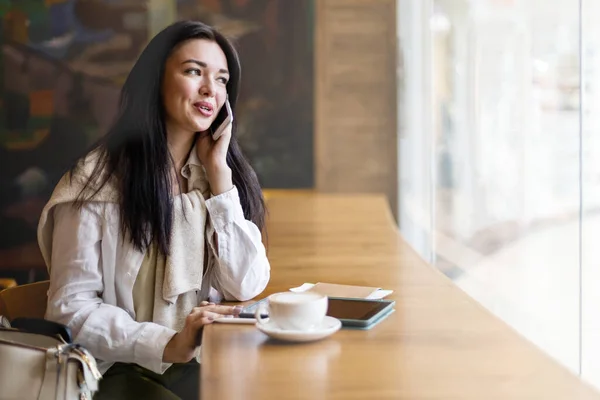 Mujer feliz sentado en la cafetería esperando vuelo de salida en la terminal del aeropuerto hablando uso de teléfono inteligente —  Fotos de Stock
