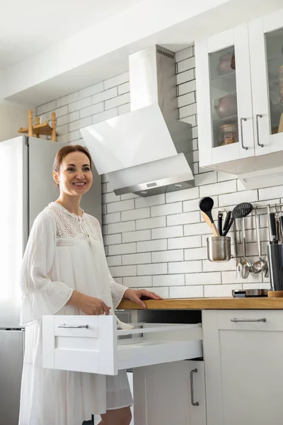 Szczęśliwa gospodyni domowa uśmiechnięta pozowanie w nowoczesnym stylu skandynawskim kuchnia organizacja przechowywania żywności — Zdjęcie stockowe