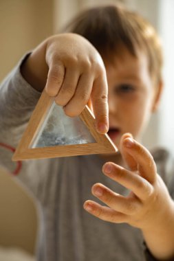 Kendi kendini geliştiren sevimli çocuk evde kinetik kum havuzu kullanıyor Maria Montessori metodu kullanıyor