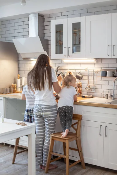 Mama i córka przygotowują lukier do piernika w domowej kuchni. Bij mikserem. Dziewczyna pomaga kobiecie.. — Zdjęcie stockowe