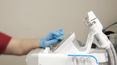 Modern klinikteki profesyonel kozmetik ekipmanların eldiven işletim ekranını kapatın..