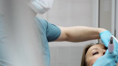 Dişçi, modern bir klinikte diş kontrolü sırasında dişleri incelemek için dahili kamera kullanır. Tıbbi eldivenler ve profesyonel ekipmanlarla dişçi prosedürünü kapatın..