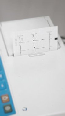 Klinik sağlık ortamında yapılan rutin kalp taraması sırasında tıbbi bir elektrokardiyogramdan çıkan ECG çıktısının kapatılması.