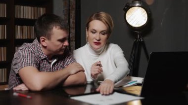 Dokümanları inceleyen ve masada dizüstü bilgisayarla stratejiyi tartışan iş adamları, danışmanlık, analiz ve kurumsal karar verme kavramı.