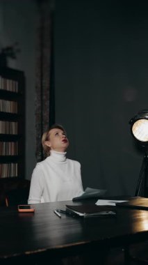 Stresli iş kadını, modern ofisteki masa başında çalışırken bir yığın kağıdı havaya fırlatıyor, aşırı yüklenme kavramı, teslim tarihi baskısı ve duygusal çöküntü..