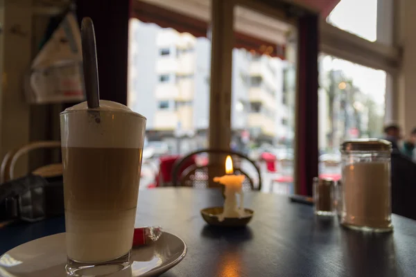 Café café con leche en la atmósfera del pequeño café con vela —  Fotos de Stock