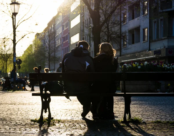 Couple Sitting Outside on Bench Silhouetted by Sun — Stock Photo, Image