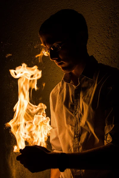 Felsőtest portréja jól öltözött fiatal férfi gazdaság tűz — Stock Fotó