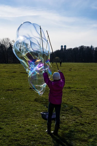 Derrière une petite fille qui souffle une bulle sur Munich Allemagne Paysage avec Frauenkirche — Photo