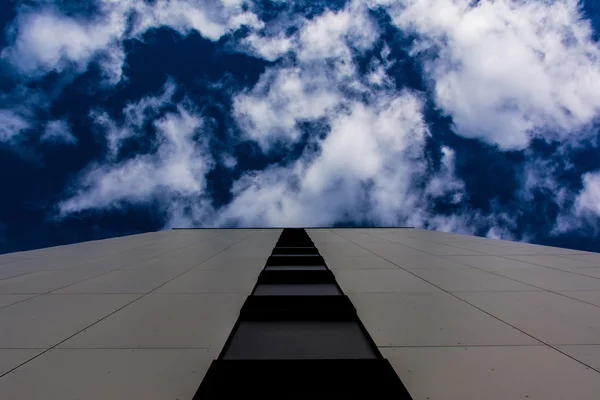 Närbild av kaklad vägg utomhus leder till djupa blå himmel och moln — Stockfoto