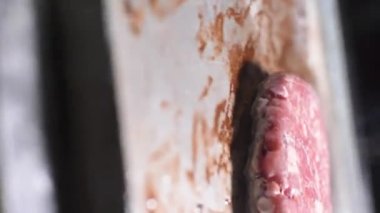 Kamera döner ve hamburger etine odaklanana kadar yakınlaşır.