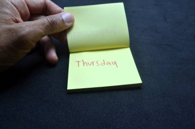 Koyu yüzey üzerine perşembe mesajı içeren sarı nota. Haftanın ritmini, kişisel planlamasını ve yaşam tarzı, ofis ve verimlilik görselleri için duygusal ses tonunu yakalıyor.