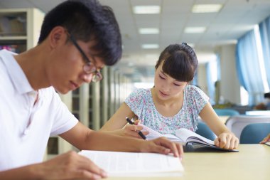 genç üniversite öğrencileri beraber kütüphanede ders