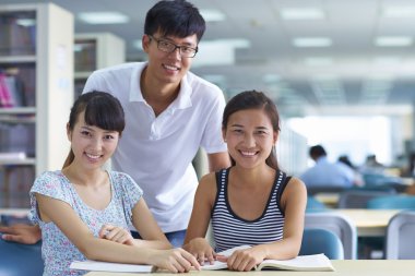 genç üniversite öğrencileri beraber kütüphanede ders