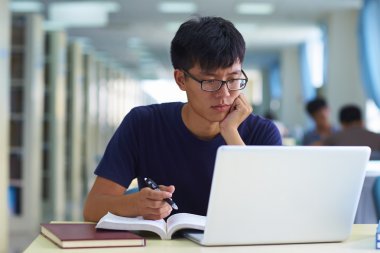 Kütüphanede bir genç adam çalışmada