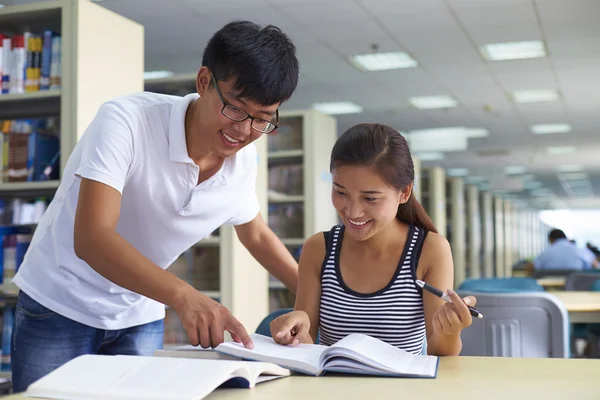 Jonge studenten studeren samen in de bibliotheek — Stockfoto