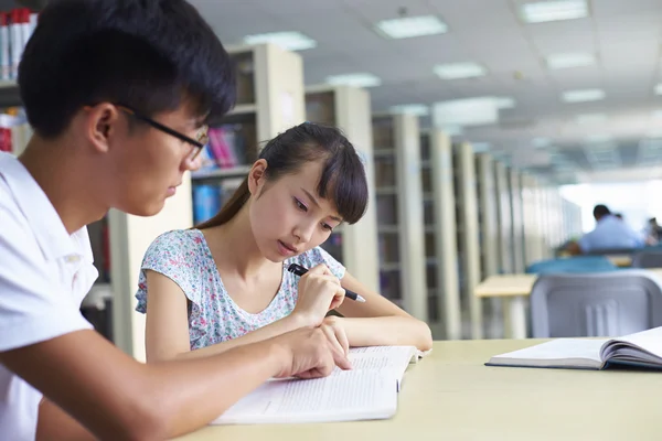 Jóvenes estudiantes universitarios estudian juntos en la biblioteca —  Fotos de Stock