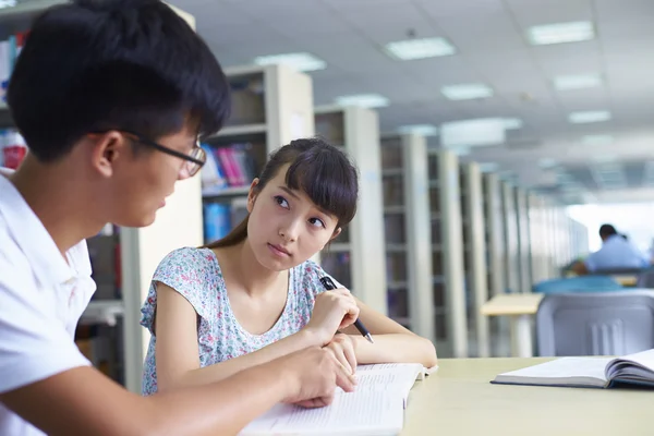 Jóvenes estudiantes universitarios estudian juntos en la biblioteca —  Fotos de Stock