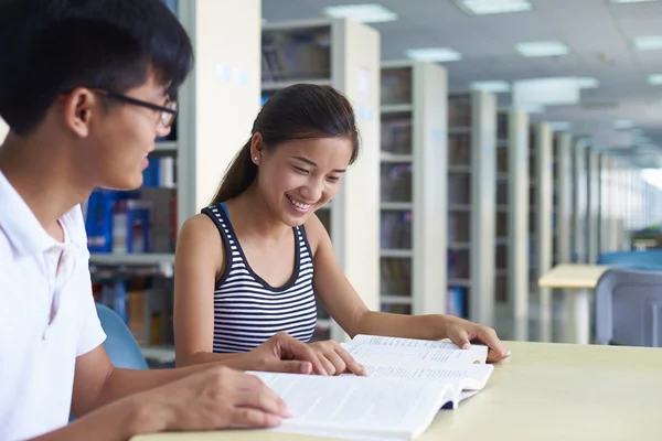 Jovens estudantes universitários estudam juntos na biblioteca — Fotografia de Stock