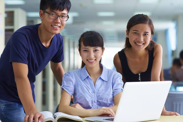 Giovani studenti universitari studiano insieme in biblioteca — Foto Stock