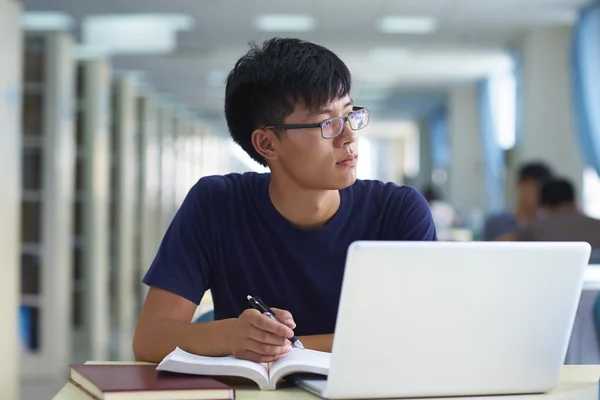 Один молодой человек учится в библиотеке — стоковое фото