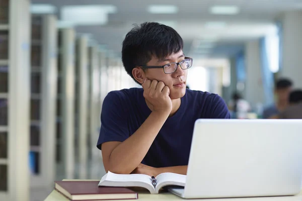 Un jeune homme étudie à la bibliothèque — Photo