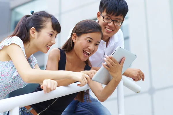 Jóvenes felices utilizando tableta al aire libre —  Fotos de Stock