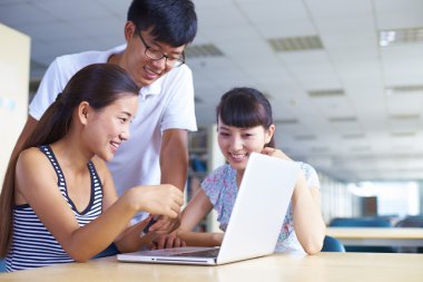 genç üniversite öğrencileri beraber kütüphanede ders