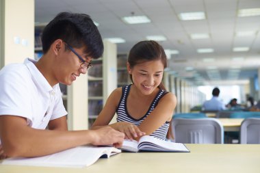 genç üniversite öğrencileri beraber kütüphanede ders