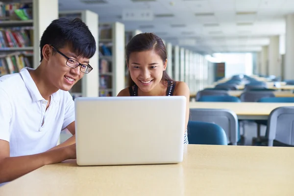 Jóvenes estudiantes universitarios estudian juntos en la biblioteca —  Fotos de Stock